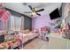 Colorful bedroom with a ceiling fan, decorated with toys and dolls at 715 Heritage Point Dr, Henderson, NV 89002