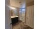 A well-lit bathroom with a glass-enclosed shower, single vanity, and a tiled floor at 7160 Mineral Park Ave, Las Vegas, NV 89179