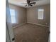 Bedroom featuring neutral carpet, two windows, and a ceiling fan, ready for personalization at 7160 Mineral Park Ave, Las Vegas, NV 89179