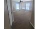 A spacious bedroom features neutral carpet, a ceiling fan, and multiple windows offering an abundance of natural light at 7160 Mineral Park Ave, Las Vegas, NV 89179