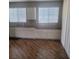Bright kitchen features white cabinets and countertops and laminate floors at 7160 Mineral Park Ave, Las Vegas, NV 89179