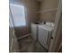 Efficient laundry room with front load washer and dryer, tile floors, and a handy wire shelf at 7160 Mineral Park Ave, Las Vegas, NV 89179