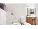 Modern bathroom featuring stylish fixtures, elegant white marble tile, and wood vanity at 744 Hubbard St, Las Vegas, NV 89110