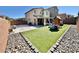 Spacious backyard featuring artificial turf, a patio area, and a playground with brick perimeter at 7468 Wellfleet Bay Ave, Las Vegas, NV 89179