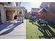 This backyard boasts a covered patio with seating, artificial lawn, and playground at 7468 Wellfleet Bay Ave, Las Vegas, NV 89179