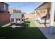 Lush backyard with artificial grass, a charming playhouse, covered patio, and cozy seating area at 7468 Wellfleet Bay Ave, Las Vegas, NV 89179