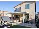 This backyard features a covered patio with seating, an artificial lawn, and a playhouse at 7468 Wellfleet Bay Ave, Las Vegas, NV 89179