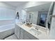 Bathroom showcasing dual sinks, large mirror, and a shower-tub combination at 7468 Wellfleet Bay Ave, Las Vegas, NV 89179