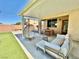 Relaxing covered patio with cozy seating, wooden table, and view of the artificial turf at 7468 Wellfleet Bay Ave, Las Vegas, NV 89179