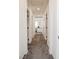 Hallway featuring gray carpet, white walls and doors with black hardware at 7468 Wellfleet Bay Ave, Las Vegas, NV 89179