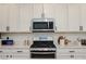 Detailed shot of a modern gas range stove and matching stainless steel microwave at 7468 Wellfleet Bay Ave, Las Vegas, NV 89179