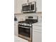 Close up of a stainless steel gas range stove and microwave at 7468 Wellfleet Bay Ave, Las Vegas, NV 89179