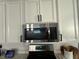 A well-equipped kitchen with stainless steel microwave and white cabinets at 7468 Wellfleet Bay Ave, Las Vegas, NV 89179
