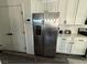 Stainless steel refrigerator adjacent to the modern white kitchen at 7468 Wellfleet Bay Ave, Las Vegas, NV 89179