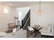 Cozy living room with dining area featuring modern furnishings, gray flooring, and a stairway at 7468 Wellfleet Bay Ave, Las Vegas, NV 89179