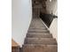 Carpeted staircase with a wooden handrail and iron balusters leading to the downstairs at 7468 Wellfleet Bay Ave, Las Vegas, NV 89179