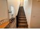 A carpeted staircase with wood railing leads to the upper level of the home at 7468 Wellfleet Bay Ave, Las Vegas, NV 89179