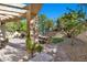 Charming backyard with a pergola-covered patio, a dining area, beautiful stone work, and well-manicured landscaping at 7627 Boca Raton Dr, Las Vegas, NV 89113