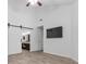 Spacious bedroom with high ceilings, wood floors, TV, and en-suite bathroom with barn door at 7627 Boca Raton Dr, Las Vegas, NV 89113