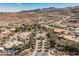 Beautiful aerial view of a luxurious community entrance with water features, palm trees, and mountain views at 764 Ricota Ct, Henderson, NV 89012
