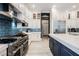 Kitchen featuring a large range, stainless steel refrigerator, blue backsplash and custom cabinetry at 764 Ricota Ct, Henderson, NV 89012
