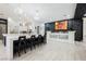 Open concept kitchen with double islands, stylish lighting, and a bar area with a black stone accent wall at 764 Ricota Ct, Henderson, NV 89012