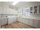 Bright laundry room with lots of cabinets, countertops, a washer, and a dryer at 764 Ricota Ct, Henderson, NV 89012