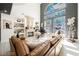 Spacious living room with a fireplace, a piano, and large windows with a view of the backyard at 764 Ricota Ct, Henderson, NV 89012