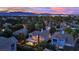 Beautiful aerial view of a residential area with picturesque rooftops, lush greenery, and distant mountains at sunset at 7837 Sea Rock Rd, Las Vegas, NV 89128
