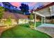 Expansive backyard with well-maintained artificial turf, lush landscaping, and a view of the hillside at 7837 Sea Rock Rd, Las Vegas, NV 89128