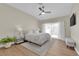 Comfortable bedroom with a ceiling fan, a light-colored rug, wood floors, and natural light at 7837 Sea Rock Rd, Las Vegas, NV 89128