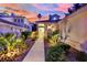 Inviting front entrance with illuminated landscaping, a walkway, and a charming facade at dusk at 7837 Sea Rock Rd, Las Vegas, NV 89128