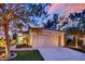 Charming single-story home with a well-manicured lawn, attached garage, and vibrant landscaping at dusk at 7837 Sea Rock Rd, Las Vegas, NV 89128