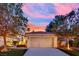 Charming home exterior at sunset featuring a well-manicured lawn, mature trees, and a two-car garage at 7837 Sea Rock Rd, Las Vegas, NV 89128