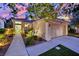 Charming single-story home featuring manicured landscaping, a two-car garage, and a cozy front porch at sunset at 7837 Sea Rock Rd, Las Vegas, NV 89128