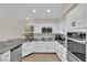Bright kitchen showcases white cabinets and stainless steel appliances with stone backsplash at 7837 Sea Rock Rd, Las Vegas, NV 89128