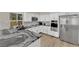 Modern kitchen featuring stainless steel appliances, granite countertops, white cabinets, and wood flooring at 7837 Sea Rock Rd, Las Vegas, NV 89128