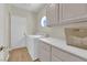 Laundry room featuring washer, dryer, counter space and cabinets, plus a porthole window at 7837 Sea Rock Rd, Las Vegas, NV 89128