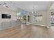 Open-concept living room featuring hardwood flooring, modern lighting, and a sliding glass door at 7837 Sea Rock Rd, Las Vegas, NV 89128