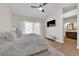 Cozy primary bedroom with wood floor, ceiling fan, tv and ensuite bathroom at 7837 Sea Rock Rd, Las Vegas, NV 89128