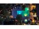 Stunning aerial view of a community pool area with glowing turquoise water, lounge chairs, and lush landscaping at dusk at 7837 Sea Rock Rd, Las Vegas, NV 89128