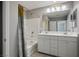 A bathroom features a double sink vanity, shower-tub, and coordinated decor at 7990 Formitch Ct, Las Vegas, NV 89166