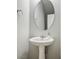 Pedestal sink with oval mirror and chrome accents in a half bathroom at 7990 Formitch Ct, Las Vegas, NV 89166