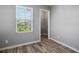 Neutral bedroom with wood-look floors, window, and walk-in closet for ample storage at 7990 Formitch Ct, Las Vegas, NV 89166