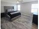 A bedroom showcases its plush upholstered headboard, wood-look flooring, and bright windows at 7990 Formitch Ct, Las Vegas, NV 89166