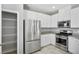 Well-lit kitchen with stainless steel appliances, white cabinets, and granite countertops at 7990 Formitch Ct, Las Vegas, NV 89166