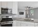 Modern kitchen with stainless appliances and gray countertops open to the living area at 7990 Formitch Ct, Las Vegas, NV 89166