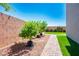 Featuring well-maintained landscape with a brick-paved pathway, young trees, and green grass at 7990 Formitch Ct, Las Vegas, NV 89166