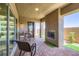 Covered patio area with brick flooring, outdoor seating, and a cozy fireplace at 800 Rosewater Dr, Henderson, NV 89011