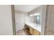 Bathroom vanity featuring a bright white counter, framed mirror and warm wood cabinets at 8070 W Russell Rd # 1046, Las Vegas, NV 89113